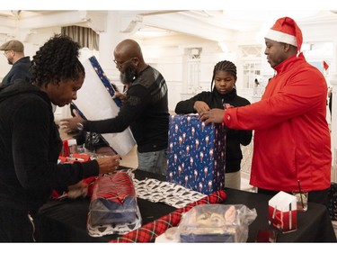 Andrienne Bowra, left to right, Forturat Telcy, Tamara Telcy and Ruben Reid wrap gifts during the Montreal Community Cares Christmas Gift Wrapping Party in Montreal on Sunday, Dec. 3, 2023.