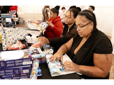 Volunteer Elizabeth Pierre wraps gifts that will be distributed later during the Montreal Community Cares Christmas Gift Wrapping Party, in Montreal, on Sunday, Dec. 3, 2023.