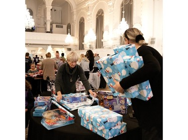 Volunteers wrap gifts for later distribution during the Montreal Community Cares Christmas Gift Wrapping Party, in Montreal, on Sunday, Dec. 3, 2023.