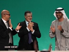 COP28 president Sultan al-Jaber, right, celebrates passing the global stocktake with United Nations Climate chief Simon Stiell, left, and COP28 CEO Adnan Amin during a plenary session at the COP28 UN Climate Summit, Wednesday, Dec. 13, 2023, in Dubai, United Arab Emirates.