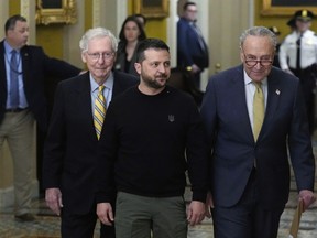 Ukrainian President Volodymyr Zelenskyy, centre, walks with Senate Minority Leader Mitch McConnell of Ky., left, and Senate Majority Leader Chuck Schumer of N.Y., right, during a visit to Capitol Hill in Washington, Tuesday, Dec. 12, 2023.