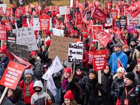 Photo shows striking teachers holding up signs during demonstration in Montreal on Nov. 23, 2023