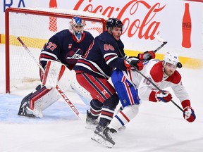 Montreal Canadiens' Joel Armia (40) is checked by Winnipeg Jets' Nate Schmidt (88) as a shot come in on goaltender Connor Hellebuyck (37) during the first period of NHL action in Winnipeg, Monday, Dec. 18, 2023.