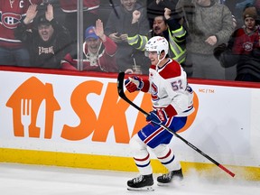 Canadiens' Justin Barron pumps his arm in front of cheering fans along the boards on the ice