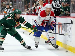 Canadiens and Wild players race for the puck along the boards