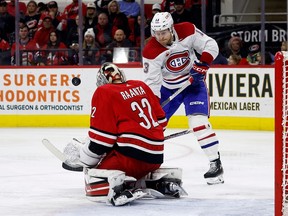 Hurricanes goaltender Antti Raanta is seen from teh side, on his knees in the butterfly position, making a save on Canadiens' Mitchell Stephens, who is to his right.