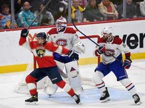 Florida Panthers' Ryan Lomberg, left, skates in front of Canadiens goaltender Jake Allen and defenceman David Savard, right, on Saturday, Dec. 30, 2023, in Sunrise, Fla.