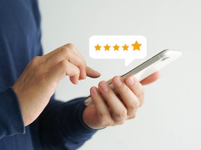 A hand using a smartphone screen with a five-star rating feedback icon