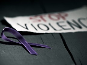 "Stop violence" is written in all-caps on a piece of paper next to a purple ribbon.