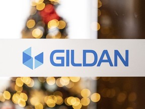The Gildan logo with a blurred Christmas tree behind it.