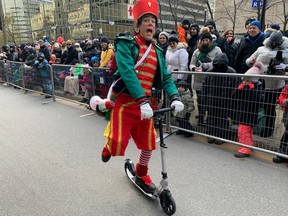 An elf rides a scooter at Montreal's 71st Santa Claus parade on Nov. 25, 2023.