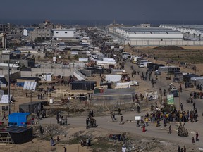 Palestinians displaced by the Israeli bombardment of the Gaza Strip gather at a tent camp, in Rafah,