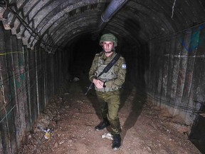 Israeli military spokesperson, Rear Adm. Daniel Hagari, speaks to the media in a tunnel the military says Hamas militants used to attack the Erez crossing in the northern Gaza Strip, Friday, Dec. 15, 2023. The army is battling Palestinian militants across Gaza to retaliate for Hamas' Oct. 7 attack on Israel.