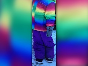 A child's clothes are pictured, including a rainbow-patterned coat, violet snow pants, pale blue gloves and what appear to be black boots with white soles.