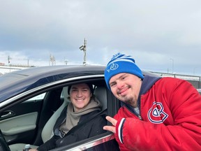 Jeremy Mylo gives a peace sign while posing for a photo with Canadiens' Samuel Montembeault outside the CN Sports Complex in Brossard.
