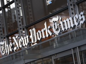 A sign for The New York Times hangs above the entrance to its building.