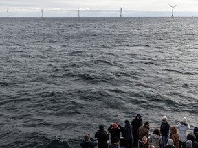 Guests observe the turbines of America's first offshore wind farm, Block Island Wind Farm, on Dec. 7, 2023, off the coast of Block Island, R.I., during a tour of the South Fork Wind farm organized by Orsted.
