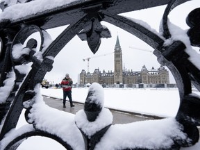 A worker prepares a pathway on Parliament Hill following a snowfall, in Ottawa, Monday, Dec. 4, 2023.
