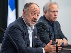 Quebec Health Minister Christian Dubé speaks at a table next to public health director Dr. Luc Boileau at a media briefing.