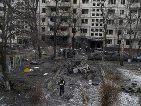 A police officer is seen in the yard of a kindergarten while investigators collected evidences after a Russian rocket attack at a residential neighbourhood in Kyiv, Ukraine, Wednesday, Dec. 13, 2023.