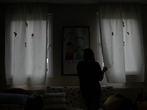 A 26-year-old woman, who wouldn't give her name for security reasons, looks through the window in safe house for women in Belgrade, Serbia, Thursday, Nov. 23, 2023.
