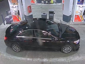 A black sedan is seen outside a convenience store in a surveillance video