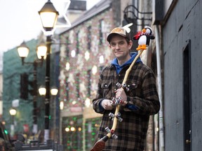 Dave Rowe, owner of O'Brien's Music Store poses with an ugly stick: a traditional Newfoundland and Labrador percussion musical instrument, outside his shop on Water St., St. John's, on Dec. 4, 2023.