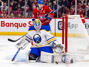 Canadiens captain Nick Suzuki watches from behind as Sabres goalie Devon Levi makes a save during first-period action at the Bell Centre Thursday night.