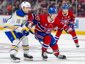 Canadiens' Juraj Slafkovsky skates through a check by Buffalo Sabres' Henri Jokiharju in Montreal on Thursday, Jan. 4, 2024.