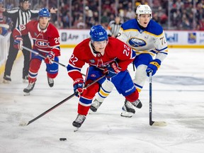 Montreal Canadiens' Cole Caufield leans over while skating with the puck toward the camera
