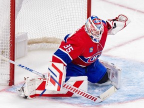 Canadiens goalie Samuel Montembeault is seen int he butterfly position in front of his net wearing the team's home red jersey.