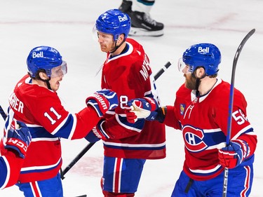 Montreal Canadiens Brendan Gallagher, left, bumps fists with Mike Matheson, centre, and David Savard