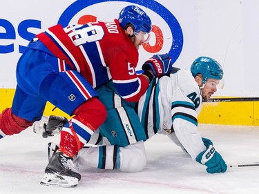 Montreal Canadiens' David Savard checks San Jose Sharks' Tomas Hertl, on all fours on the ice