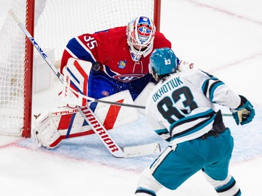 The puck goes under the stick-side arm of Canadiens goalie Sam Montembeault, with San Jose Sharks' Nikita Okhotiuk in front