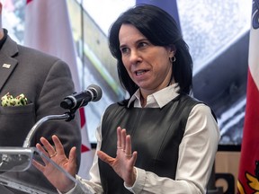 Valérie Plante holds her hands in front of her while speaking at a podium during a news conference