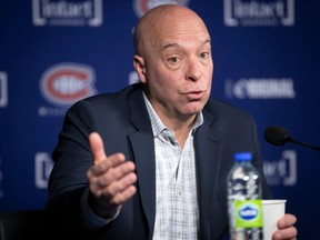 Canadiens GM Kent Hughes is seen sitting behind a microphone at a press conference on Monday.