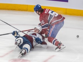 Canadiens' Michael Pezzetta, right, dumps Avalanche defenceman Josh Manson on his backside after a check Monday night at the Bell Centre.