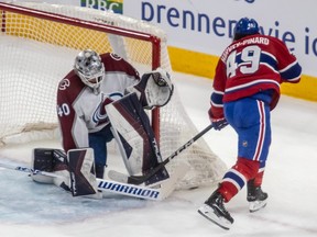 Montreal Canadiens' Rafael Harvey-Pinard skates by the side of the net with his stick in the corner in front of the Avalanche goalie