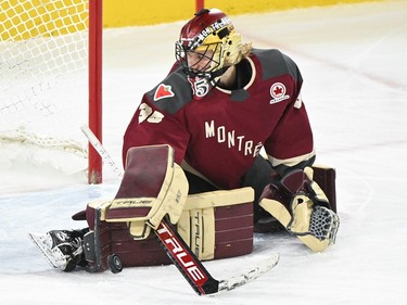 A goaltender in a Montreal jersey stops a goal.