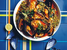 Mussels in a white bowl on a blue and yellow cloth.