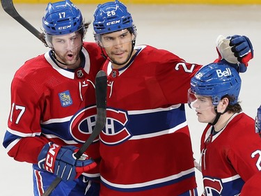 Montreal Canadiens' Johnathan Kovacevic puts his arms around other Canadiens players on the ice