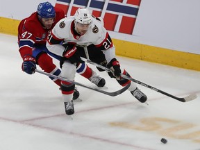 Montreal Canadiens' Jayden Struble tries to reach around Senators' Mathieu Joseph to get to the puck