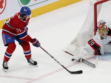 Ottawa Senators goaltender Joonas Korpisalo uses his stick and blocker to stop a shot beside his goal crease, with Canadiens' Jake Evans beside him
