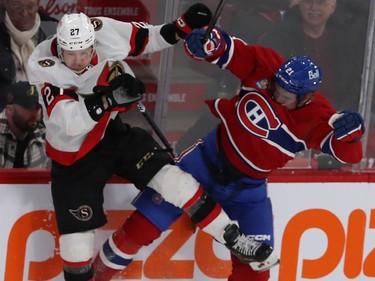 Ottawa Senators' Parker Kelly (27) and Montreal Canadiens' Kaiden Guhle (21) go up in the air after colliding near the boards