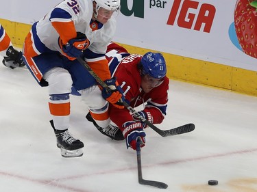 Montreal Canadiens' Brendan Gallagher dives towards the puck behind Islanders' Adam Pelech