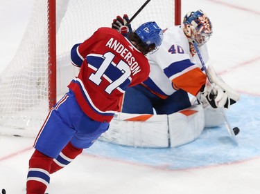 Josh Anderson skates beside the Islanders net as goaltender Semyon Varlamov handles a puck in front of him in the crease