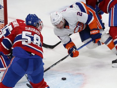 New York Islanders' Kyle Palmieri falls to the ice while staring at the puck in front of him in the Montreal crease