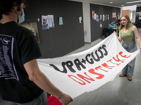 Two Concordia students unfurl a banner in preparation for a student strike against tuition hikes.