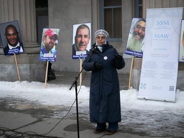 Samira Laouni speaks into a microphone with photos of men on placards behind her