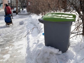 A recycling bin is placed in the snow.